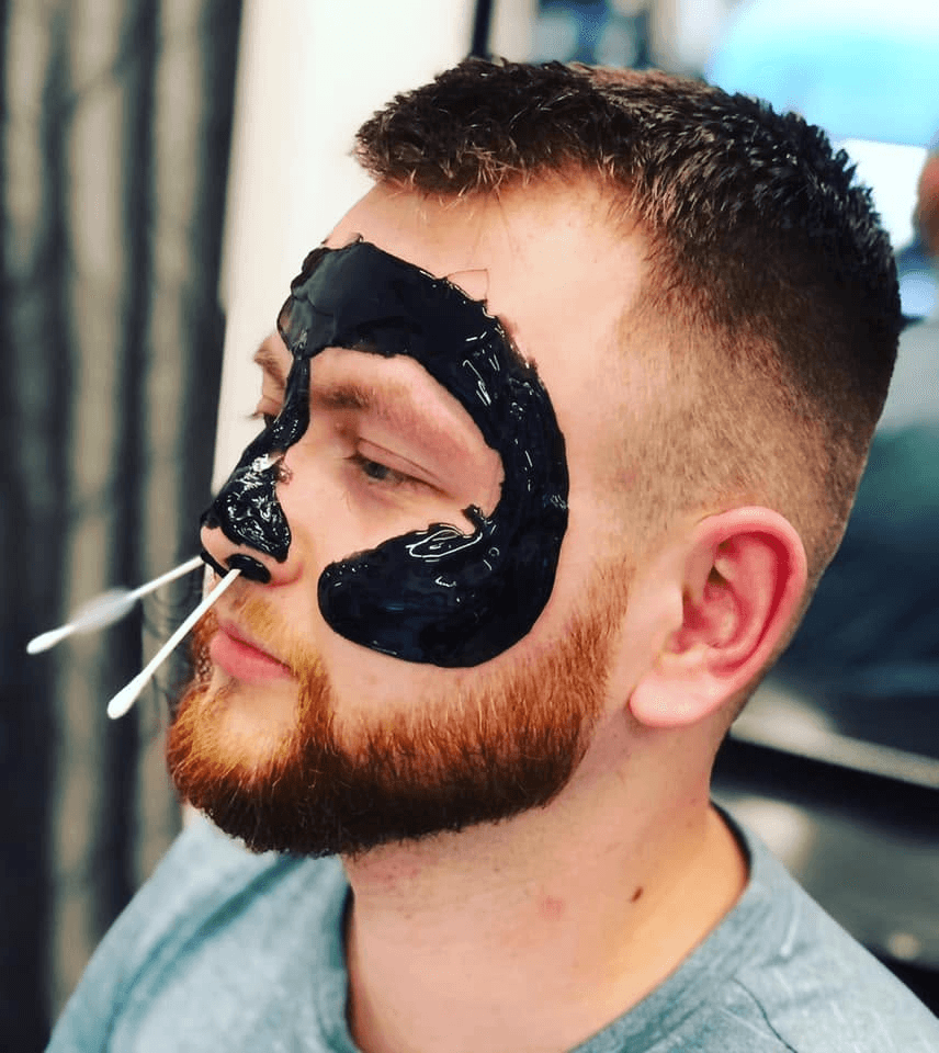Skin fade with a black peel mask and nose wax in the chair